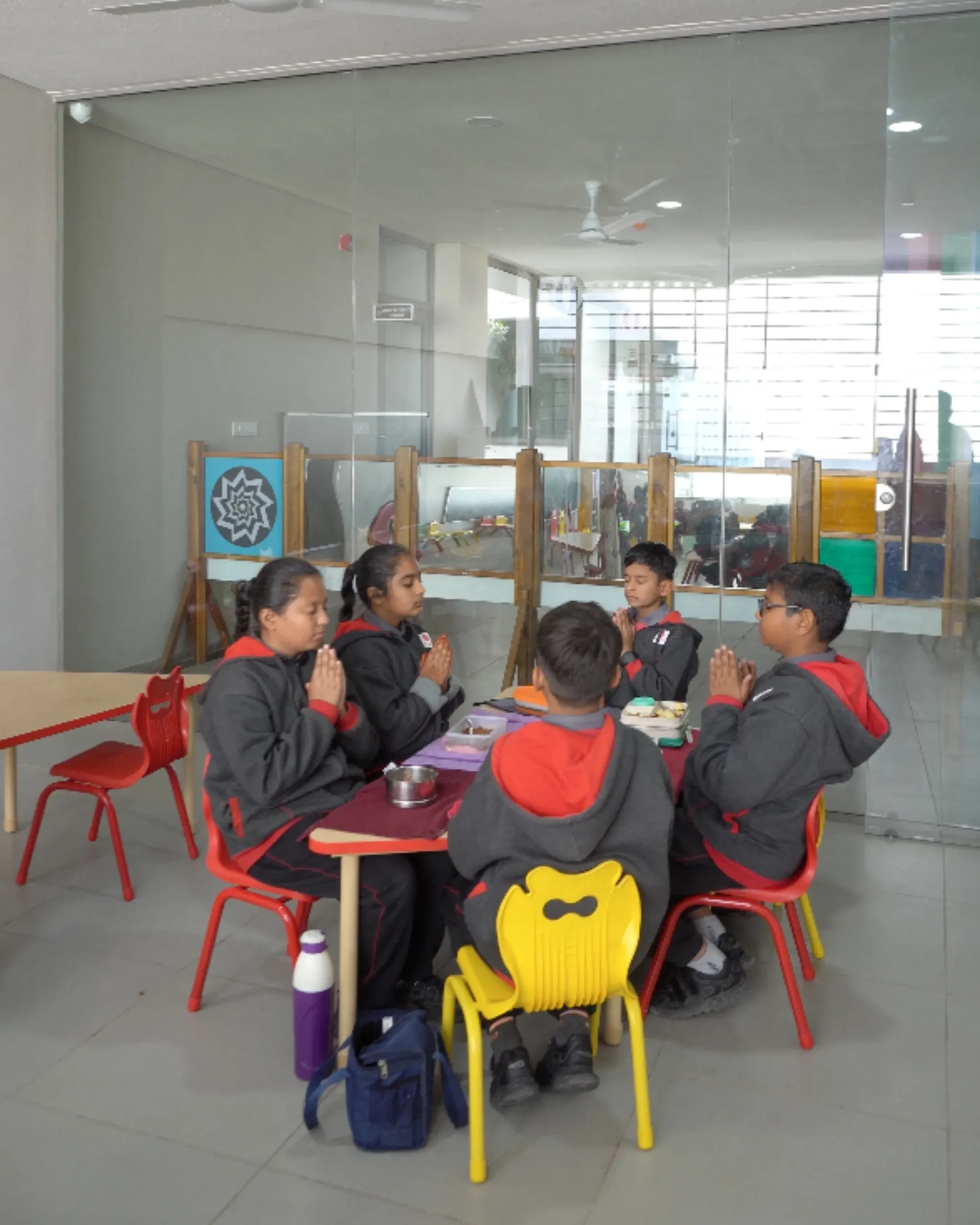 School Children Praying Before Meal In Classroom