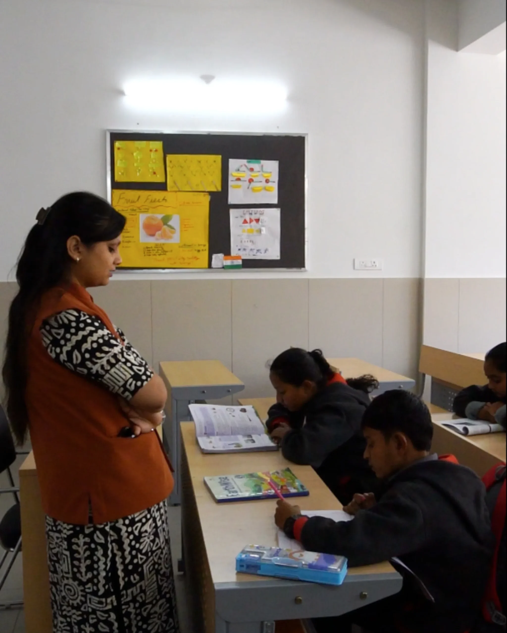 Teacher Supervising Students In Classroom