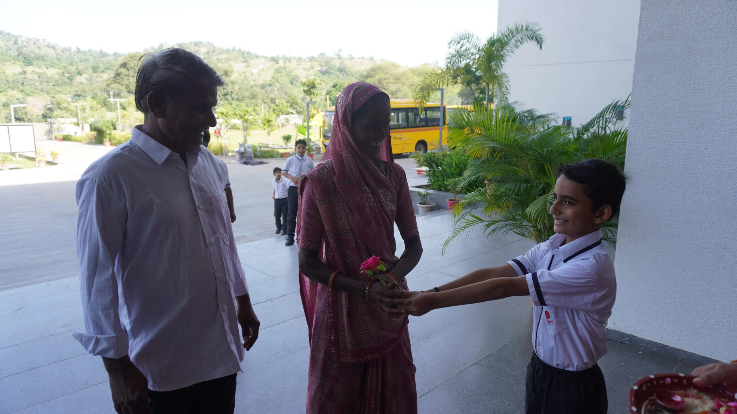 Indian grandmother and grandchildren smiling together at the school event